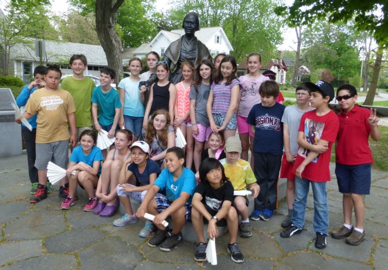 Children on a walking tour pose around Sojourner Truth statue near Ruggles Center in Florence, Massachusetts